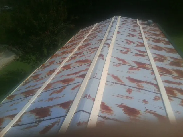 Rusted metal roof panels with new wood purlins before replacement — Storm Damage Roof Repair in Spencerport by Roofing Brothers