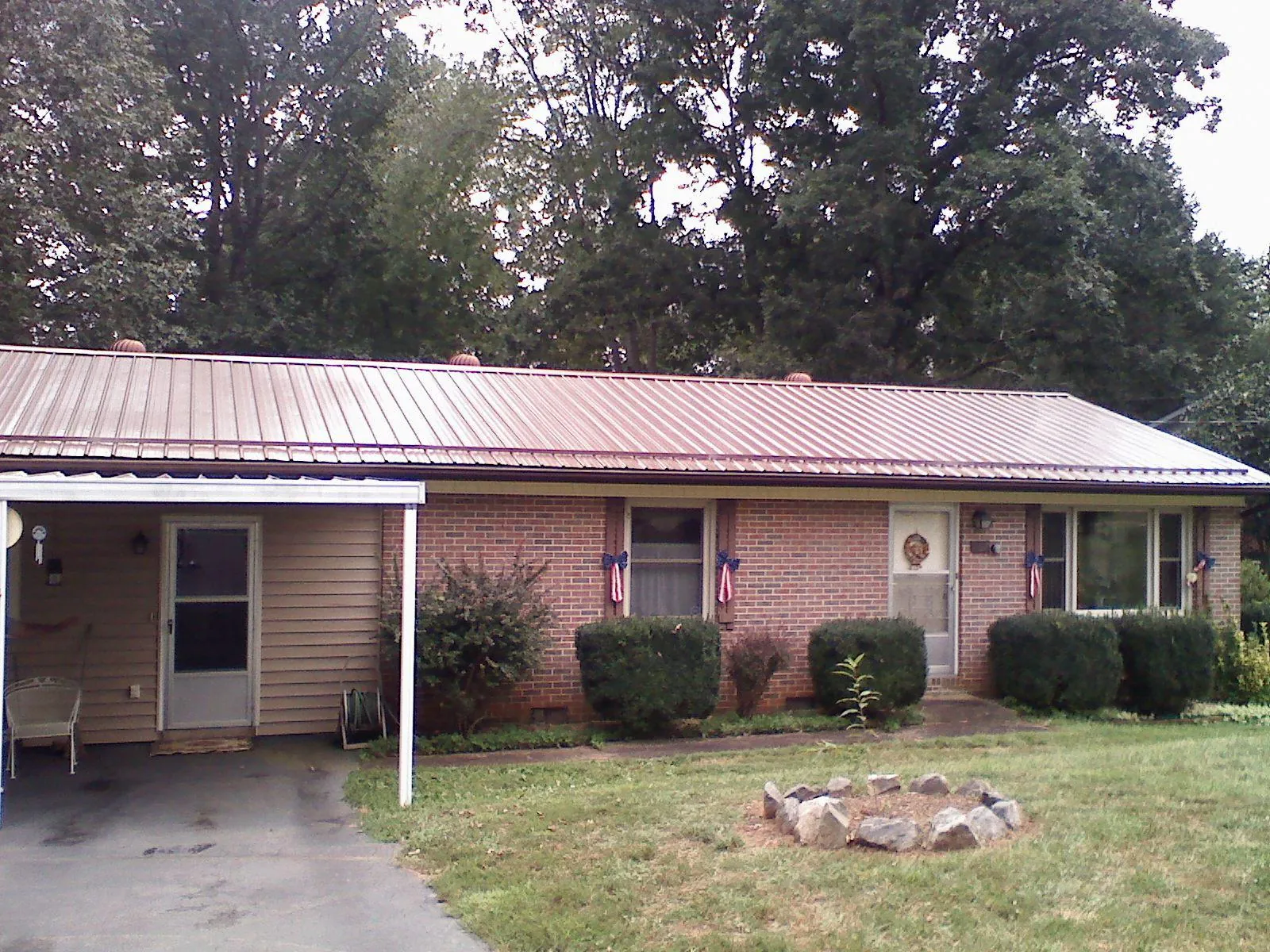 Bronze metal roof and carport on a brick ranch home — Roof Repair work by our crew in Spencerport
